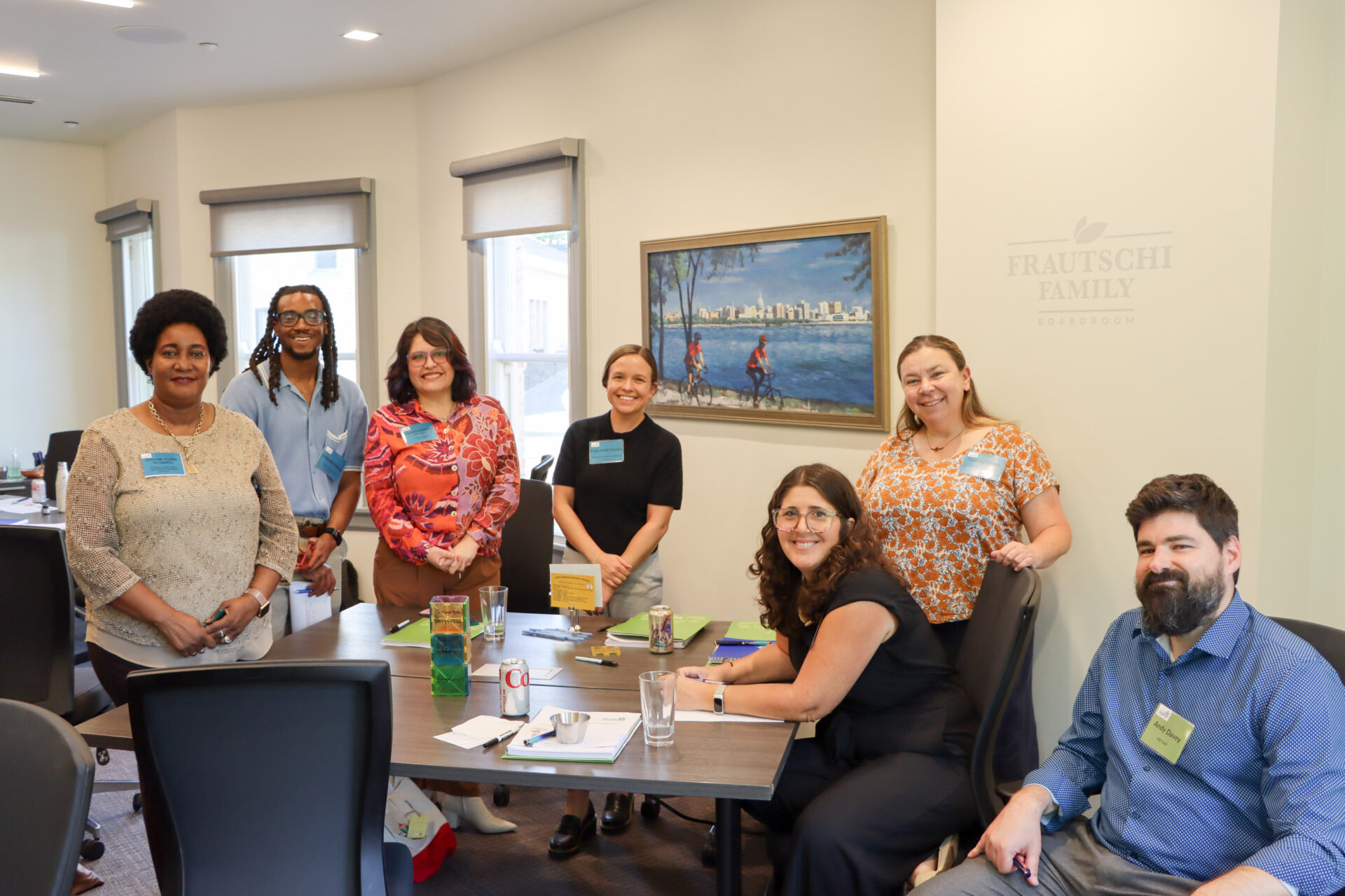 Group of fellows smile with center director during a workshop activity